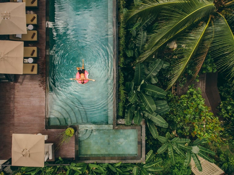 Aerial view of luxury resort with man on inflatable ring in pool