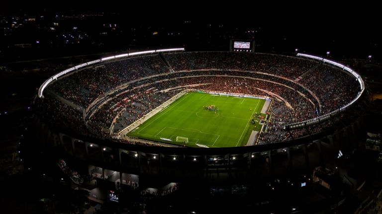 Professional football stadium at night with packed crowd and stadium lights glowing