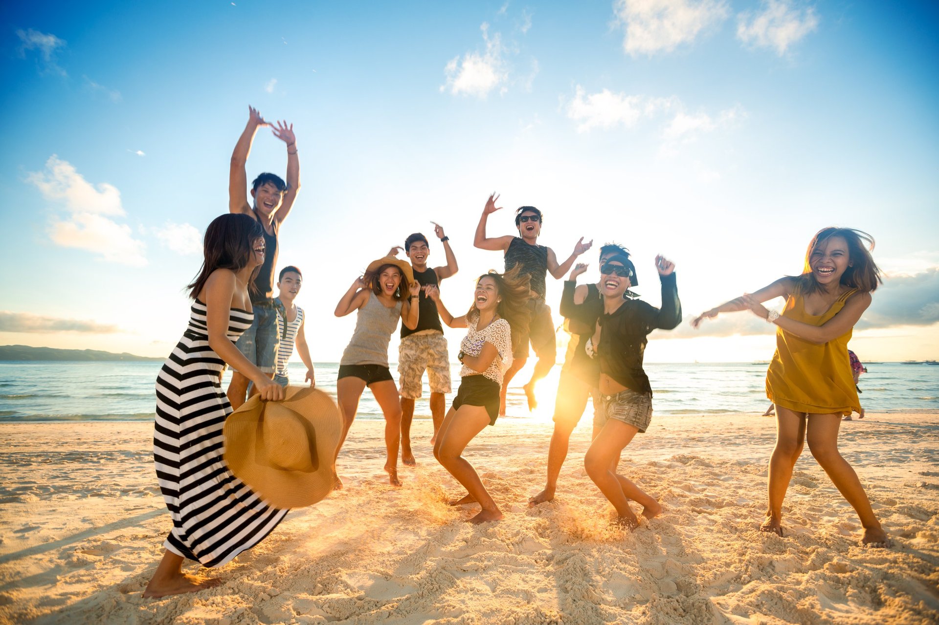 Happy young people on beach vacation celebrating together